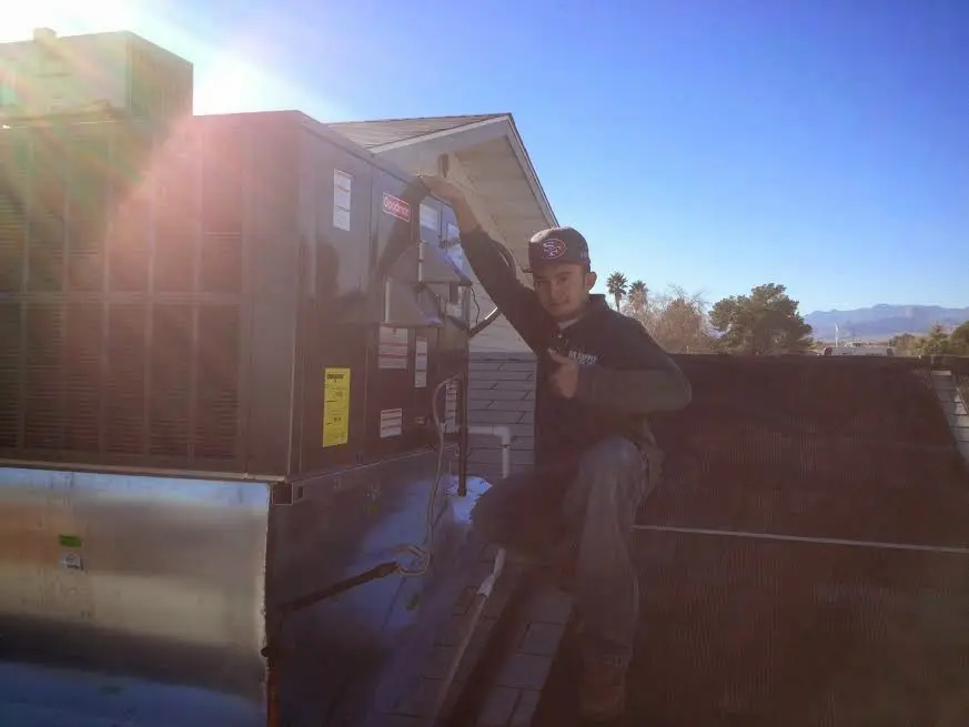 HVAC technician performing AC Tune-Up on a rooftop unit in Longmeadow